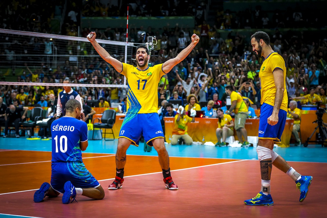 Imagem de pessoas jogando vôlei no fim de tarde.